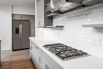 a kitchen with white cabinets and a stove top oven